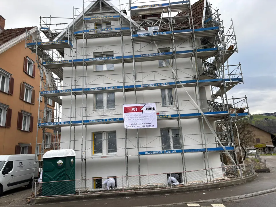 Altbau im Gerüst mit dem Banner der Fit Gips GmbH